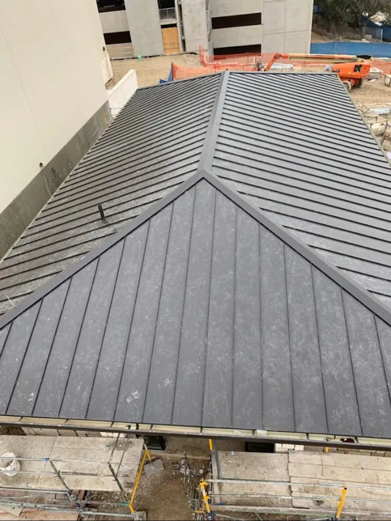 Commercial metal roof construction with crane equipment in Morris